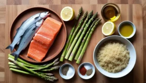 Ingredients for a grilled salmon and quinoa bowl with asparagus and lemon.