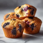 Amazing gluten free blueberry muffins with golden tops and moist tender crumb showing blueberries throughout