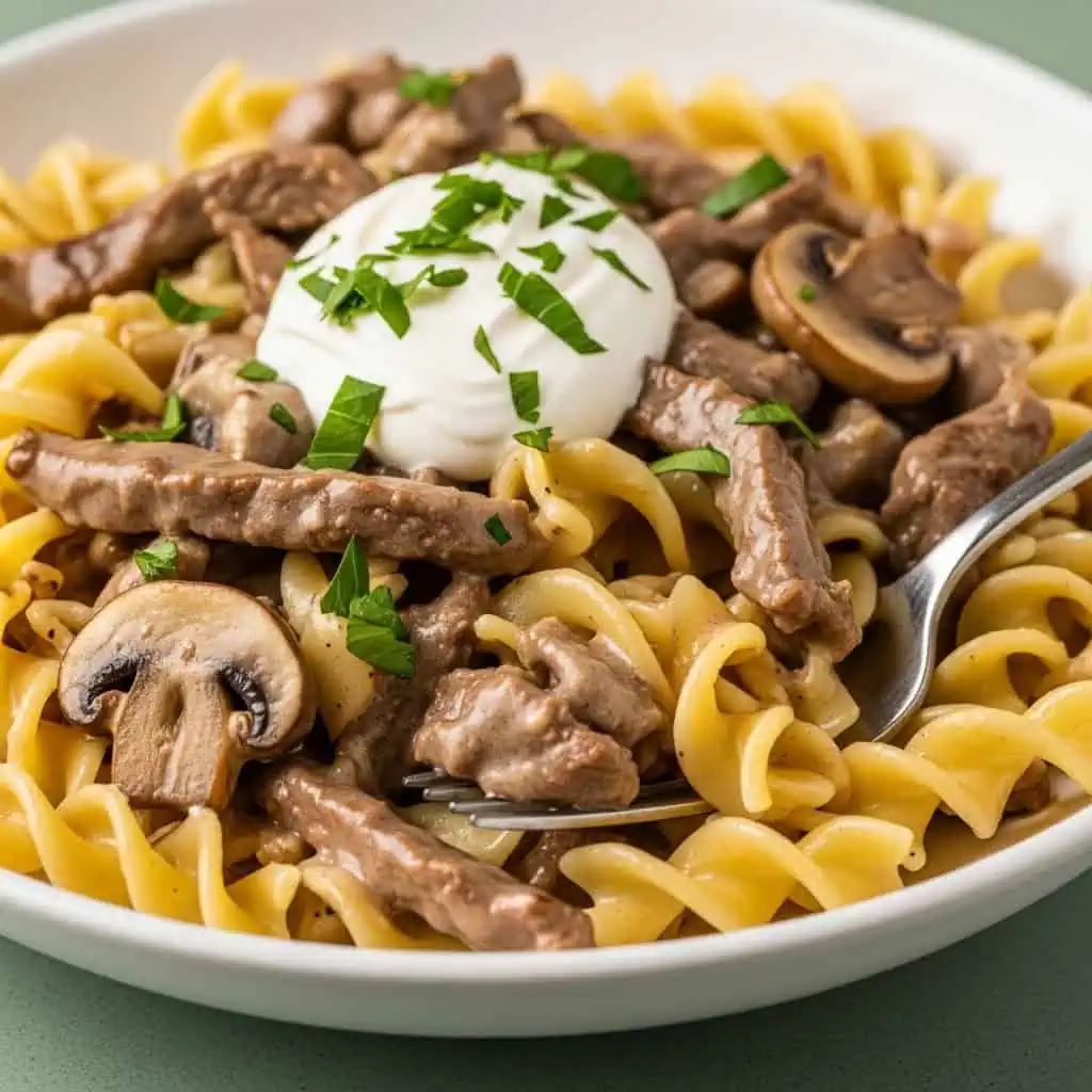 Finished one pot beef stroganoff in bowl with creamy sauce, beef, and mushrooms