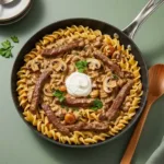 One pot beef stroganoff in skillet with tender beef, mushrooms, and egg noodles in creamy sauce